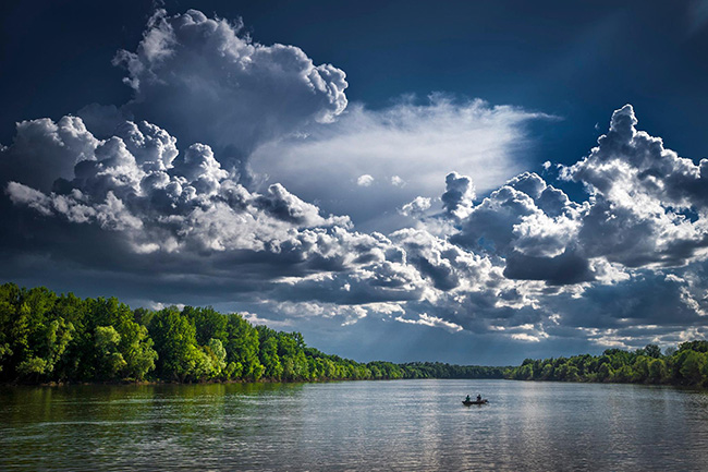 Billowing clouds over body of water
